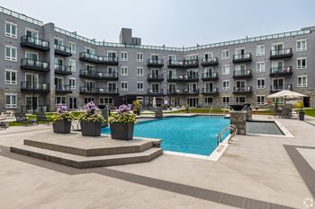 A large apartment complex with a pool and a patio area.